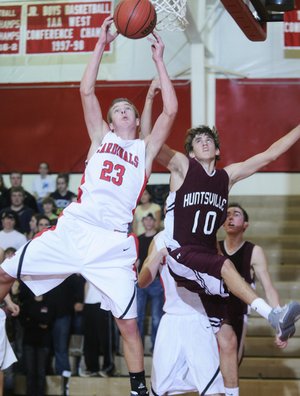 Farmington’s Jason Purdy rebounds the ball over Huntsville’s Tucker Trumbo in the second half of Tuesday’s game in Farmington.
