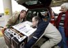 Employee David Hill (left) helps Darin Hahn of Fayetteville lift a generator into a vehicle Wednesday outside The Home Depot in Fayetteville as Darin’s mother, Donna, watches. Darin Hahn plans to use the generator at his home in case he loses power during the expected winter storm.