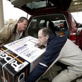 Employee David Hill (left) helps Darin Hahn of Fayetteville lift a generator into a vehicle Wednesda...