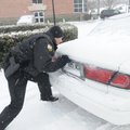 Bentonville Police Officer Steve Vera helps push a stalled car off South Walton Blvd. in Bentonville...