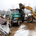 Austin Crawley, right, tops off Bryan Smith's dump truck with sand Friday, Jan. 29 at the Bella Vist...