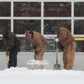  Workers with the City of Bentonville Water Department shovel snow Friday, Jan. 29 from the front of...