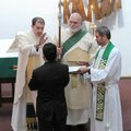Bishop Larry Benfield, left, lays hands on Guillermo Castillo on Jan. 24 to receive him into the Epi...