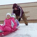 Iris, left, and Lilly Feltner get a push from their dad, Joshua Feltner, while sledding at Greer Lin...