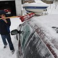 Manuel Martinez, 13, uses a broom to clean the snow and ice off of his family's van Saturday, Jan. 3...