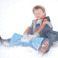 Caleb Garner, 7, of Fayetteville winces as snow flies into his face as he sleds down a hill north of...