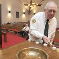 IN MEMORY - Allen Moots, American Legion District 1 chaplain, Post 100, lights a candle Sunday durin...