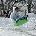    Tanner Gustin, 15 of Farmington, catches air as he hits a jump on a sledding saucer at Wilson Par...