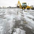 Matt Johnson, a maintenance worker with Fayetteville Public Schools, clears ice and slush from the s...
