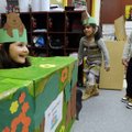 Myia Taylor, 6, from left, pretends to be a groundhog looking for her shadow Tuesday as Charleigh Ry...