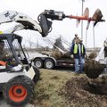acob Denton, right, places a tree in the ground Wednesday with other Fayetteville Parks and Recreati...