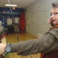 Physical education teacher Deb Walter shows one of the target bows students shoot during the archery...