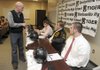 Bentonville football coach Barry Lunney talks with seniors Hayden Boydston, Jon-Mark Holden, and Chase Petersen, from left, on Wednesday in Bentonville before they signed letters of intent to play college football. Boydston signed with Fort Scott, Kan., Community College, Holden signed with the University of Central Arkansas, and Petersen signed with the University of Louisville. 