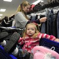 Adeline Patterson, 2, kicks back in a shopping cart Thursday as her mother, Aubrey, searches for clo...