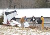  Officials with the Washington County Sheriff's Office collect information at the site of a plane crash Saturday, Feb. 6 north of Winslow that claimed four lives.