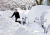 Mark Jordan digs a vehicle out from a pile of snow Sunday in Washington, where sunshine spurred residents to start cleaning up from the weekend’s winter storm.