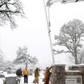 A Bentonville Electric Department crew sets a new 30-foot flagpole at Bentonville Cemetery in Benton...