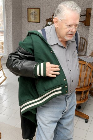 63 YEARS LATE - Jack Tickner puts on the Central Methodist University letterman’s jacket Friday he received Christmas Day. Tickner talked about the jacket at his home in Bentonville.