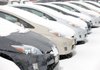 Snow covers a row of unsold 2010 Prius sedans at a Toyota dealership in Lakewood, Colo., on Sunday.