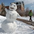    University of Arkansas student Erin Hauser from Huntsville passes by a snowman in near Old Main o...
