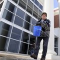 Crystal Vickers, custodian at Har-Ber High School, spreads ice melt Tuesday in front of a side entra...