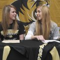  Bentonville’s Sydney Thurow, left, talks with Shanna Seyfarth before signing to play college volley...