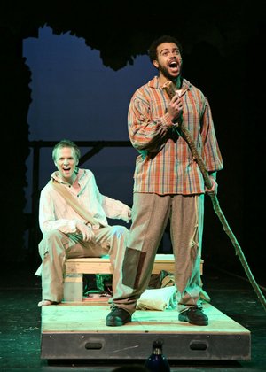 Runaway slave Jim, played by Justin Stewart, right, and Huck Finn, played by Ramond Curtis, float on a raft down the Mississippi River in the Rogers Little Theater’s production of “Big River,” which opens this weekend.