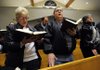 MEMORIAL SERVICE - Barbara Postert, left, Stephen Postert and Mary Salnicki, all of Omaha, Neb., sing “How Great Thou Art” while attending a memorial service Friday for James Ahern at St. Bernard Catholic Church in Bella Vista. Ahern, 41, was shot to death on Jan. 20 by Bella Vista Police Cpl. Coleman Brackney following a high-speed chase. The incident is still under investigation. Barbara Postert and Salnicki are the sisters of Ahern.

