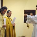 Josh Kellam, right, anoints the Rev. John Antony of St. Joseph Catholic Church, from left, the Rev. ...
