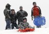Theo Hamrin, 8, sleds down a hill at Country Club Golf Course as Shane Stewart, left, Jaylen Stewart, 13, Robert Hamrin and Connor Disney look on Jan. 29 as heavy snow falls in Bella Vista.

