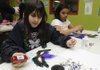 Adriana Stanley, 9, left, and Kenya Ivy, 11, both of Bentonville, decorate masks Wednesday at the McKinney Unit of the Boys & Girls Club of Benton County in Bentonville. The masks will be available for purchase at the club’s Feb. 20 fundraiser, Mardi Gras Masquerade Ball.
