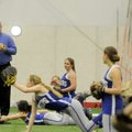 Rogers softball coach Mike Harper tosses balls during a catching drill Thursday at the school’s indo...