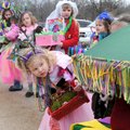 MARDI GRAS MAMBO - Morgan Leaton, 3, bends for a look into a stroller Sunday while waiting for a par...