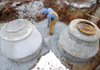 Zach Cheatham of Harvco Inc. spreads gravel Thursday while working on the installation of a main septic line inside the Northwest Second Street construction zone in downtown Bentonville. Harsh winter weather has delayed Phase 3 of the Downtown Enhancement Project several times since work began on Jan. 11.