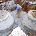 Zach Cheatham of Harvco Inc. spreads gravel Thursday while working on the installation of a main sep...