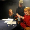 Mark Warren, center, puts a microphone on host Shannon Caine, right, and Lauren Brakebill on Friday ...