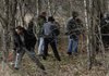 Bentonville police and Benton County sheriff’s deputies comb a wooded area on Sugar Creek Road just south of Pea Ridge on Tuesday afternoon. Investigators found human remains in a shallow grave alongside a creek that authorities believe to be those of two women missing since June.