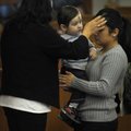  Maria F. Mironta, left, administers ashes to Maria G. Pena, holding her daughter, Aidenn, at the en...
