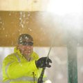Eric Larson, a worker with the Fayetteville Parks and Recreation Division, uses a pressure washer to...