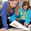 Fourth-graders Stormy Lane, left, and Gracie Williams look through a book Wednesday about zombies, w...