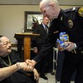Rogers Police Chief Steve Hamilton thanks Shelby Briggs, resident council president, for her part of...