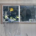 Springdale firefighters throw debris out a window Tuesday after a mobile home was filled with heavy ...