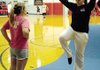 Coach Courtney Hurst, shown here with Lacy King, works with her cheer team continually encouraging them to do their best.