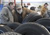 STAFF PHOTOS J.S. WEDGEWORTH 
Shannon Wicker, left, and his father, Paul Wicker, both of Crane, Mo., look at tires Wednesday before the start of the auction at Bob Maloney Ford in Rogers.