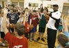  Ricky Pierce divides students into small groups  at the beginning of a basketball clinic at Bentonville High School Saturday evening.