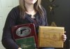 Nikki Pinto, 17, shows her plaque from the International Defensive Pistol Association national championship and Oklahoma state championship.