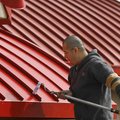  Ben Martinez of Springdale paints an awning at Chick-fil-A  on College Ave. in Fayetteville Sunday ...