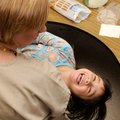 Teacher Heather McCoy holds a squirming Natalie Valdez, 3, on Tuesday at Bentonville Head Start Cent...