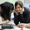 Rani Henson, middle, 12, smiles as she works Tuesday on a Dr. Seuss learning game with Paolo Canova,...