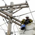 Jason Ritchie, journeyman lineman with Swepco, repairs a broken power line Tuesday that stretches ac...